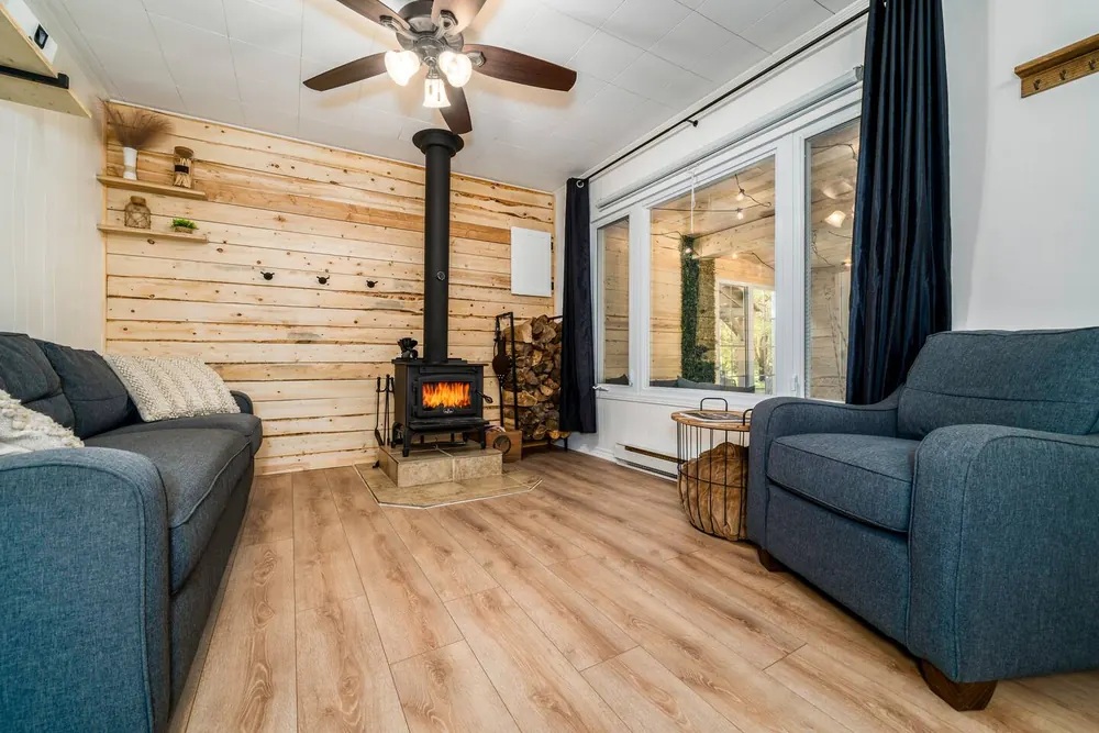 Salon chaleureux avec poêle à bois et mur en bois